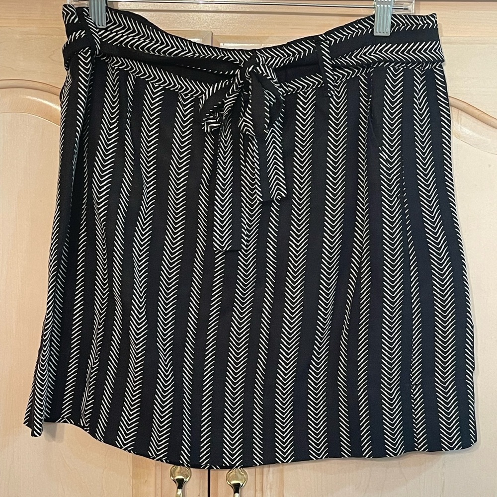 The Loft black and white pull on skirt has a matching tie belt. Size L .
